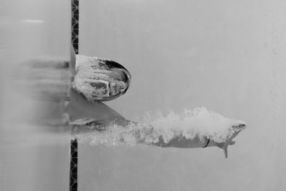 Person Swimming at the Pool in Grayscale Photo