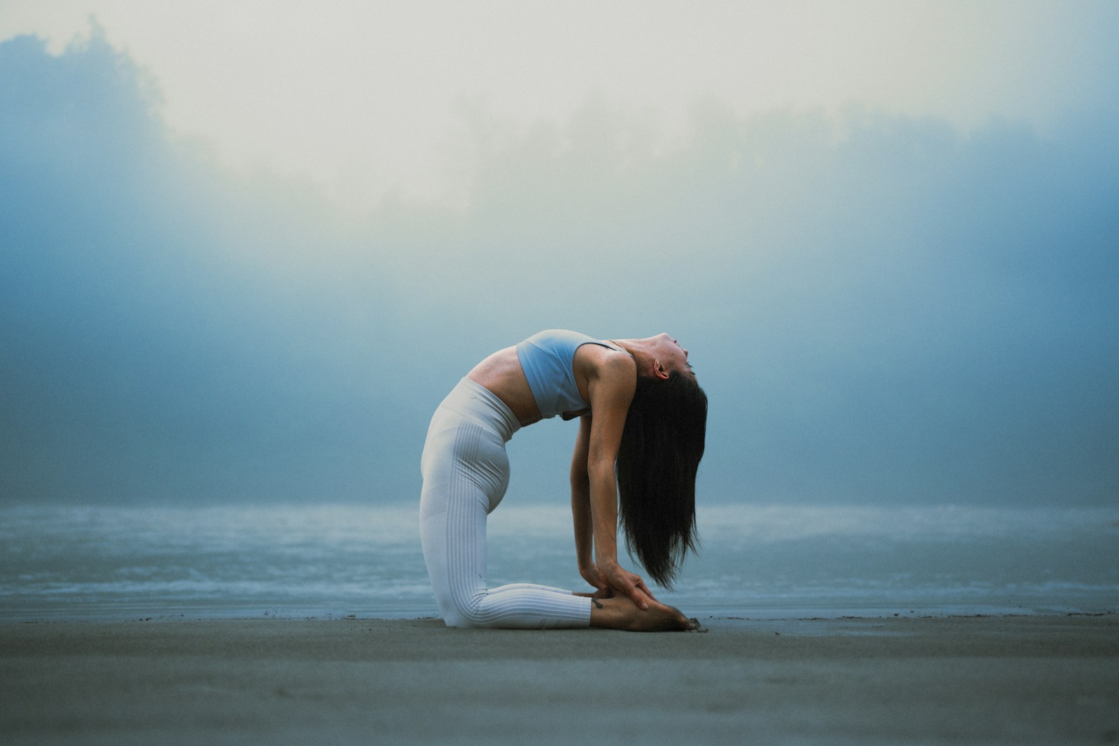 A woman doing a yoga pose on the beach