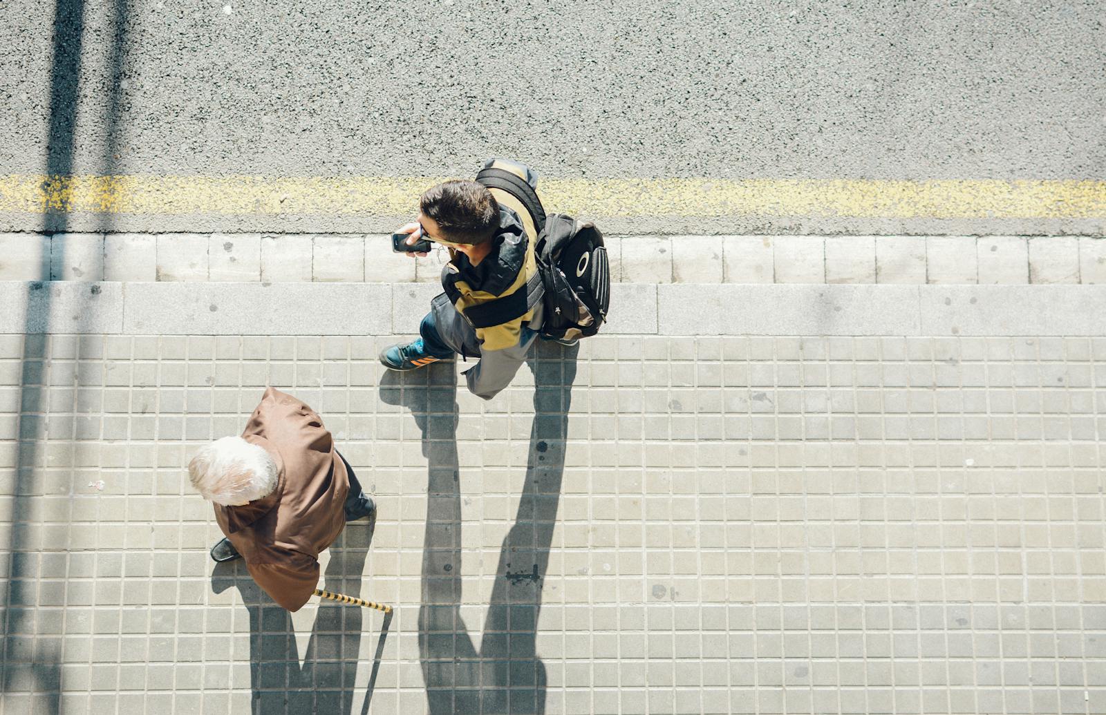 Top view of people walking on a sunny street in Barcelona, Spain.