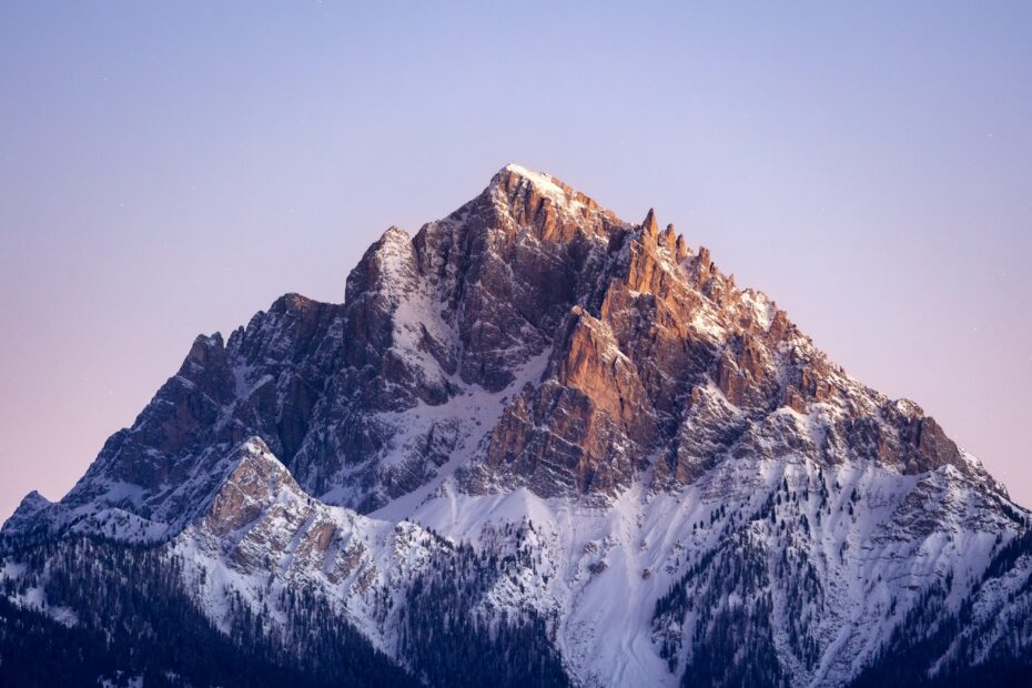 A snow covered mountain with a blue sky in the background