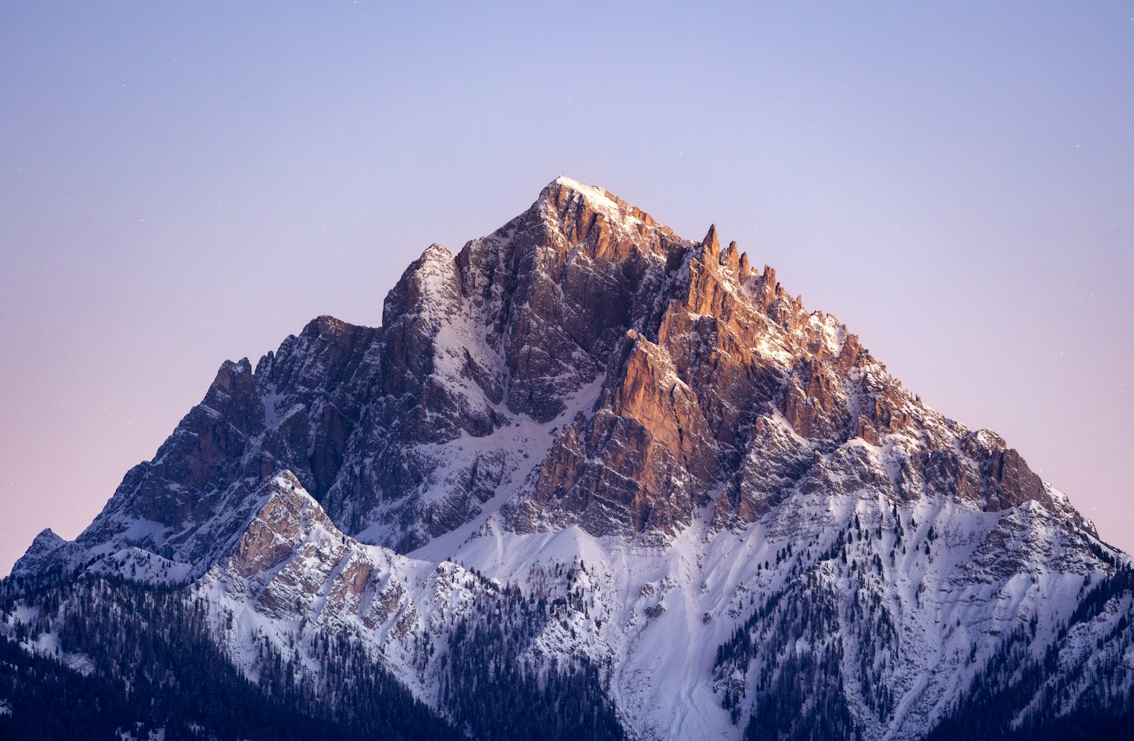 A snow covered mountain with a blue sky in the background